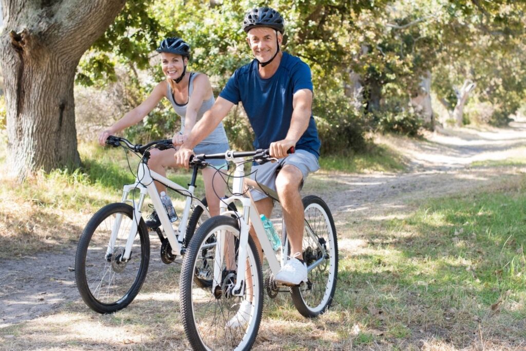 健康的夫妇在迪拜公园户外健身训练公园早上一起骑自行车