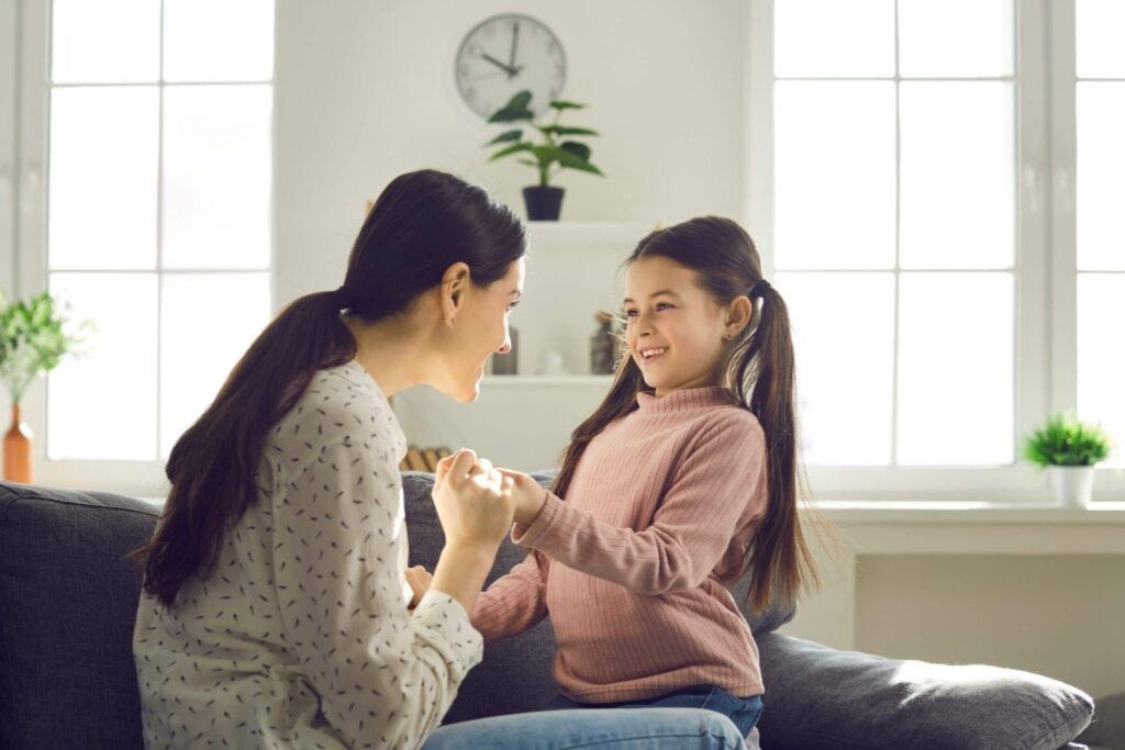 घर पर युवा बेटी के साथ बातचीत करती माँ आत्मविश्वासी बच्चे भावनात्मक पेरेंटिंग लचीले सचेत