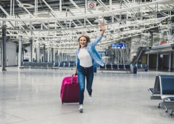 旅客带着行李箱在迪拜机场出发口周末逍遥游航班冒险旅行目的地