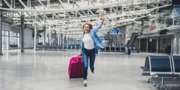 旅客带着行李箱在迪拜机场出发口周末逍遥游航班冒险旅行目的地