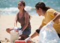 Volunteers collecting plastic waste during beach cleanup environmental champions sustainability leaders green