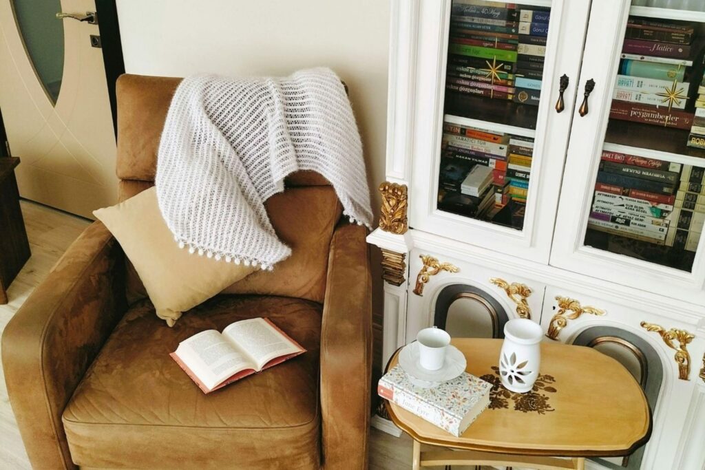 舒适的阅读角，配有椅子、毯子和暖色灯光，营造舒适生活家居Hygge温暖