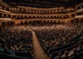 Dubai Opera performance with elegant stage lighting and audience - DUBAIwebzine Dubai Opera performance with elegant stage lighting and audience Opera Season performance cultural artistic shows