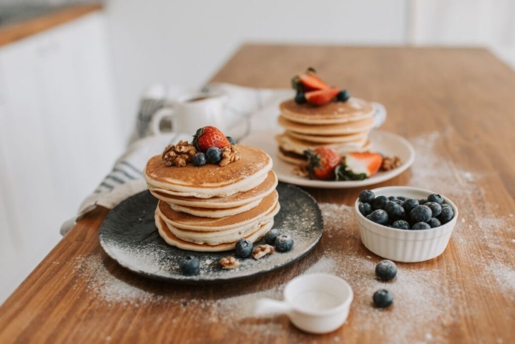 ताजे जामुन और सामग्री के साथ घर के बने ग्लूटेन-फ्री पैनकेक ग्लूटेन-फ्री नाश्ता स्वस्थ व्यंजन पौष्टिक प्रोटीन