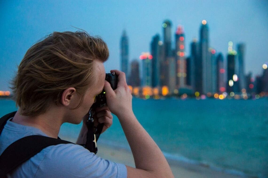 مصور محترف في مرسى دبي على الواجهة البحرية لليخوت - DUBAIwebzine مصور فوتوغرافي محترف يوثق تصوير اليخوت الفاخرة على واجهة دبي مارينا المائية مع أفق المدينة، ممثلاً لأفضل أماكن التصوير لمحتوى السفر