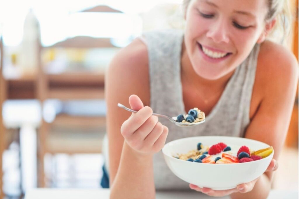 दुबई वेलनेस कैफे में ग्लूटेन-फ्री नाश्ते का आनंद लेती महिला ग्लूटेन-फ्री नाश्ता स्वस्थ पौष्टिक व्यंजन