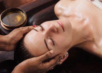 Женщина получает аюрведическую процедуру для лица с травяными маслами в роскошном спа-салоне Аюрведические ритуалы красоты целостное сияние