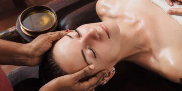 女士在豪华水疗中心接受阿育吠陀面部护理，使用草本精油，体验阿育吠陀美容仪式，焕发整体光彩