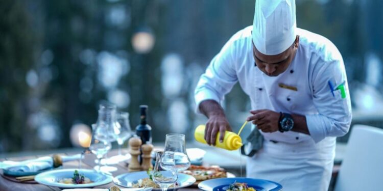 दुबई के मिशेलिन-तारांकित रेस्तरां में एक प्रसिद्ध सेलिब्रिटी शेफ शानदार फाइन डाइनिंग डिश परोसते हुए, जो विश्व-स्तरीय भोजन अनुभवों के लिए विशिष्ट व्यंजन बनाने वाले पाक कला के दिग्गजों का प्रतिनिधित्व करते हैं