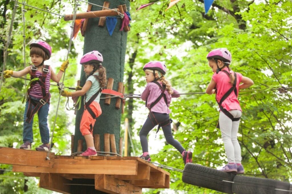 ग़फ़ के पेड़ के जंगल में एवेन्टुरा पार्क्स दुबई में प्रकृति-आधारित स्कूल की छुट्टियों की गतिविधियों का अन्वेषण करते बच्चे, ज़िप-लाइनिंग, उत्तरजीविता कौशल और पर्यावरण सीखने के साथ बाहरी शिक्षा शिविरों का प्रदर्शन करते हुए