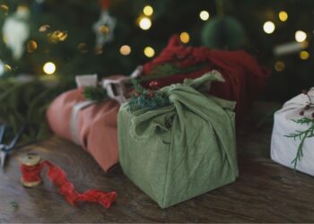 पुनर्नवीनीकृत और पर्यावरण-अनुकूल जैविक कपड़े में खूबसूरती से लपेटे गए टिकाऊ क्रिसमस उपहार