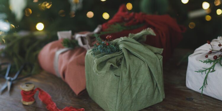 पुनर्नवीनीकृत और पर्यावरण-अनुकूल जैविक कपड़े में खूबसूरती से लपेटे गए टिकाऊ क्रिसमस उपहार