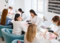 Young women students manicure nail salon Dubai affordable - DUBAIwebzine Young women students enjoying affordable manicure services at budget-friendly beauty spots in Dubai, showcasing accessible self-care options for university students and young professionals
