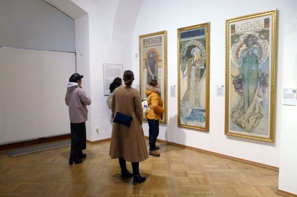 Collectionneurs d'Art Dubai examinant des œuvres d'art avec un représentant de galerie pendant l'expérience du guide des visiteurs à la foire