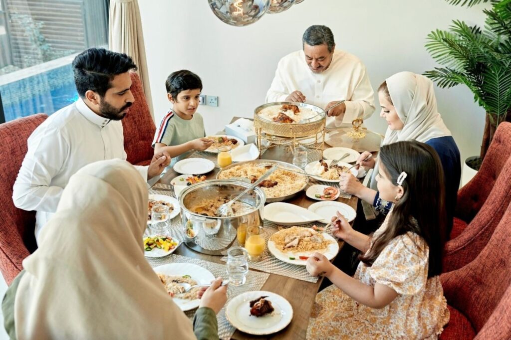 Dîner en famille dans un restaurant de Dubaï pendant l'Aïd el-Fitr, illustrant l'hospitalité et la croissance du commerce de détail