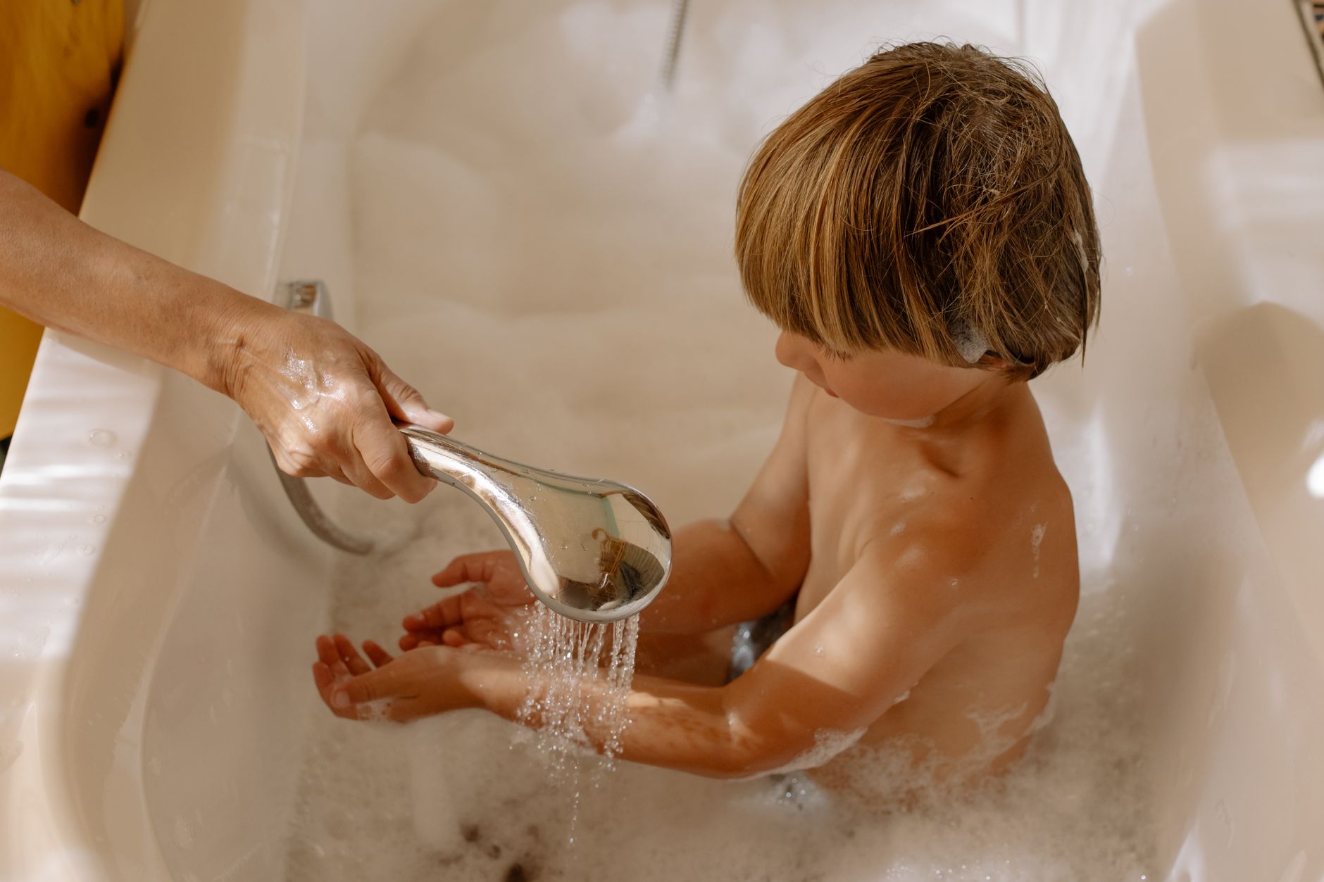Une personne installant un pommeau de douche à faible débit comme mesure pratique pour réduire la consommation d'eau à la maison à Dubaï