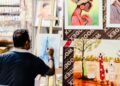 A designer works at a wooden table inside a warehouse studio that forms part of the Dubai design scene at Alserkal Avenue