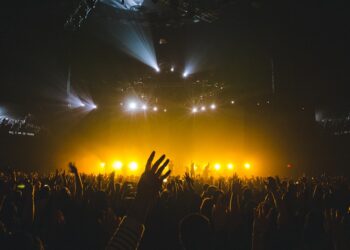 Excited fans singing along at a Beach Boys Dubai concert inside a large indoor arena