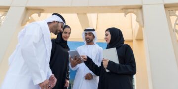 entrepreneur_signing_business_documents_Dubai - DUBAIwebzine A startup founder completes free zone registration paperwork at a modern Dubai business center
