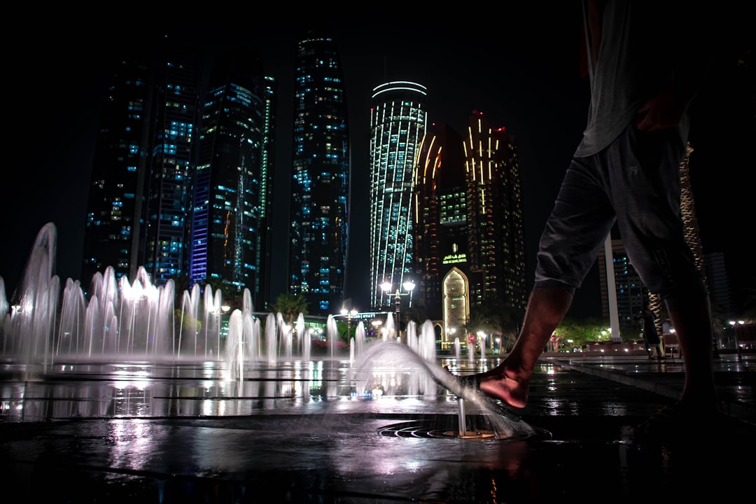 A family watches the Dubai Fountain at night, celebrating the Hijri New Year holiday in the Downtown district.