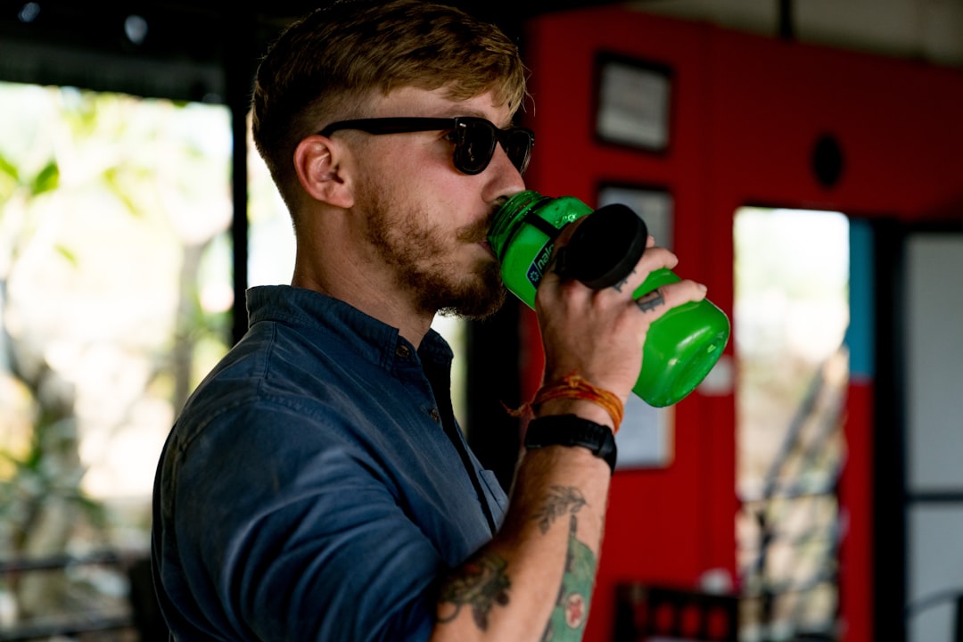 A man hydrating with water after an indoor gym workout in Dubai, an important part of how to stay active safely in summer