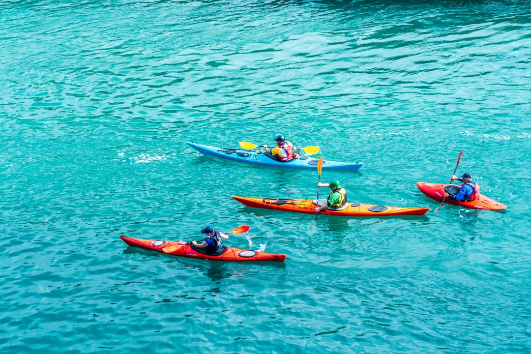 Two tourists kayaking on the clear turquoise water at Hatta Dam, a popular destination for day trips from Dubai