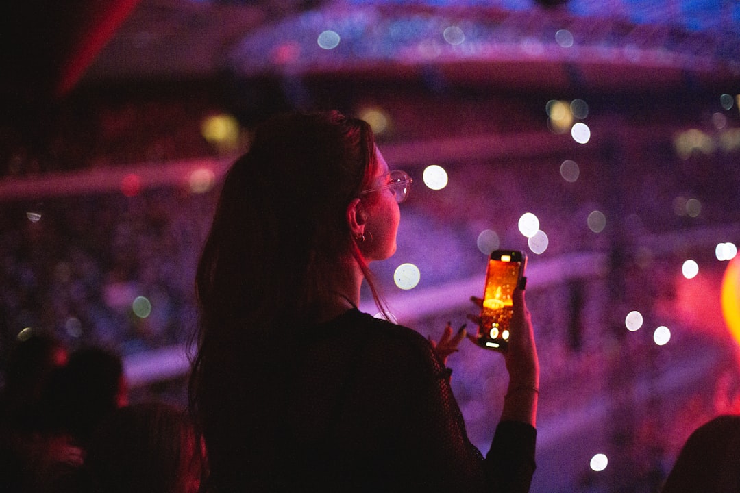 A fan purchasing Beach Boys Dubai tickets online on her smartphone before the show