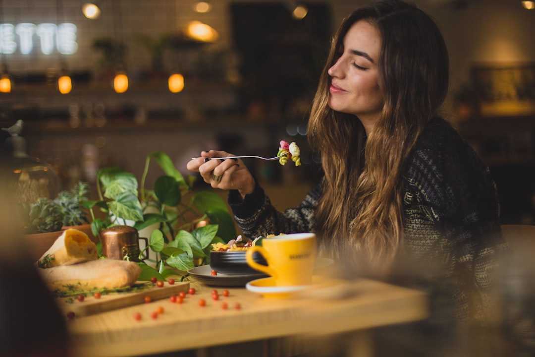 A woman enjoying a plant-based meal at a cafe, reflecting the growing culture of gluten-free bakeries and mindful eating