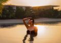 A woman relaxing by a luxury hotel pool during a Dubai staycation in summer