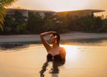 A woman relaxing by a luxury hotel pool during a Dubai staycation in summer