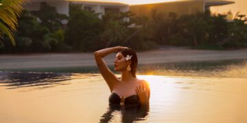 A woman relaxing by a luxury hotel pool during a Dubai staycation in summer