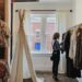 A woman browses slow fashion garments at an ethical boutique in Dubai, examining fabric quality with care.