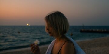 woman-walking-dubai-beach-unsplash - DUBAIwebzine A visitor walks along Dubai Creek during the Hijri New Year long weekend, with the water behind her.