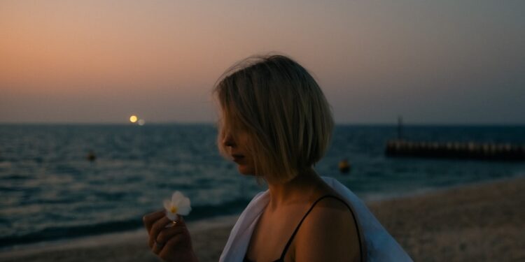 woman-walking-dubai-beach-unsplash - DUBAIwebzine A visitor walks along Dubai Creek during the Hijri New Year long weekend, with the water behind her.