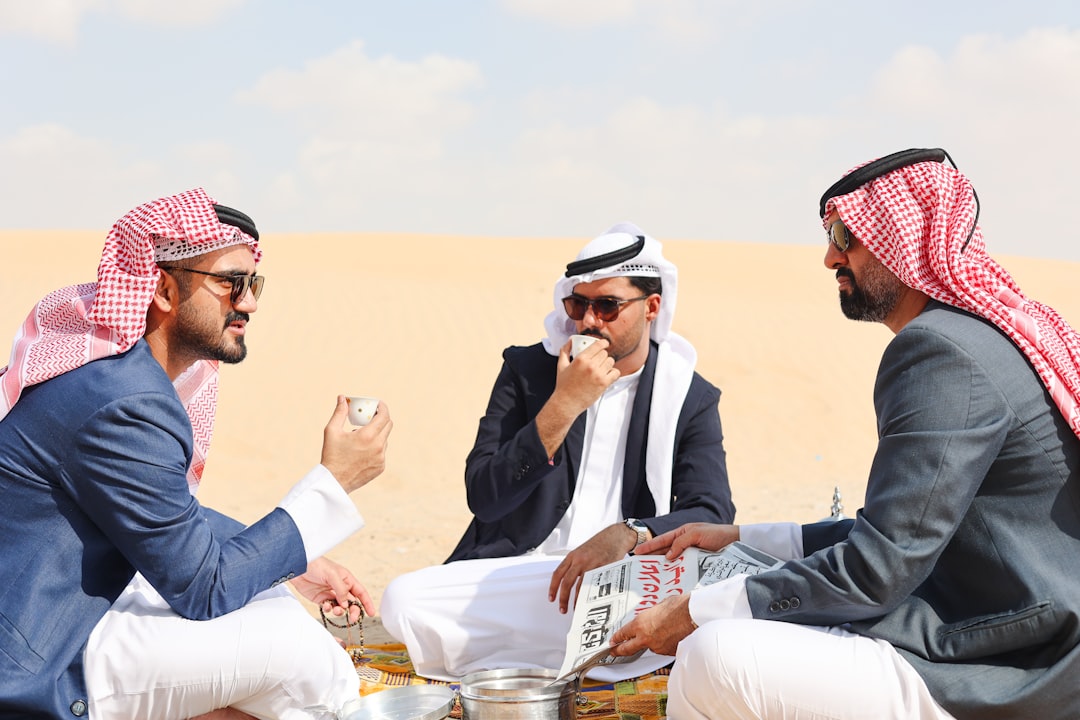 Guests share a traditional Emirati meal in a majlis setting, connecting with Arabic culture through food and conversation