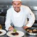 A professional chef presents a certified gluten-free dining dish at a fine restaurant in Dubai
