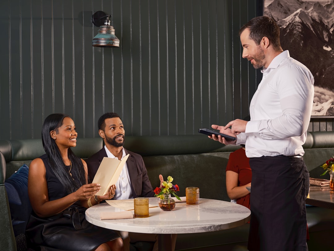 Una pareja usando un teléfono para reservar su mesa en la semana de restaurantes de verano en un restaurante de Dubai
