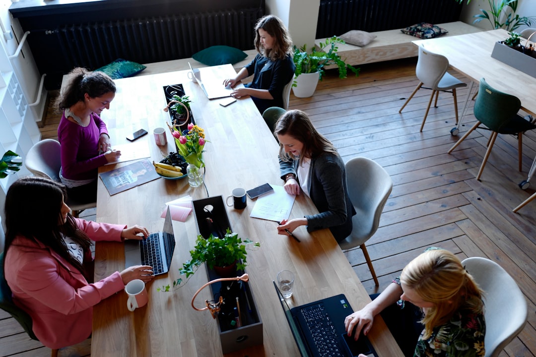 A group of digital nomads collaborating at a modern coworking space in Dubai, surrounded by screens and open workstations