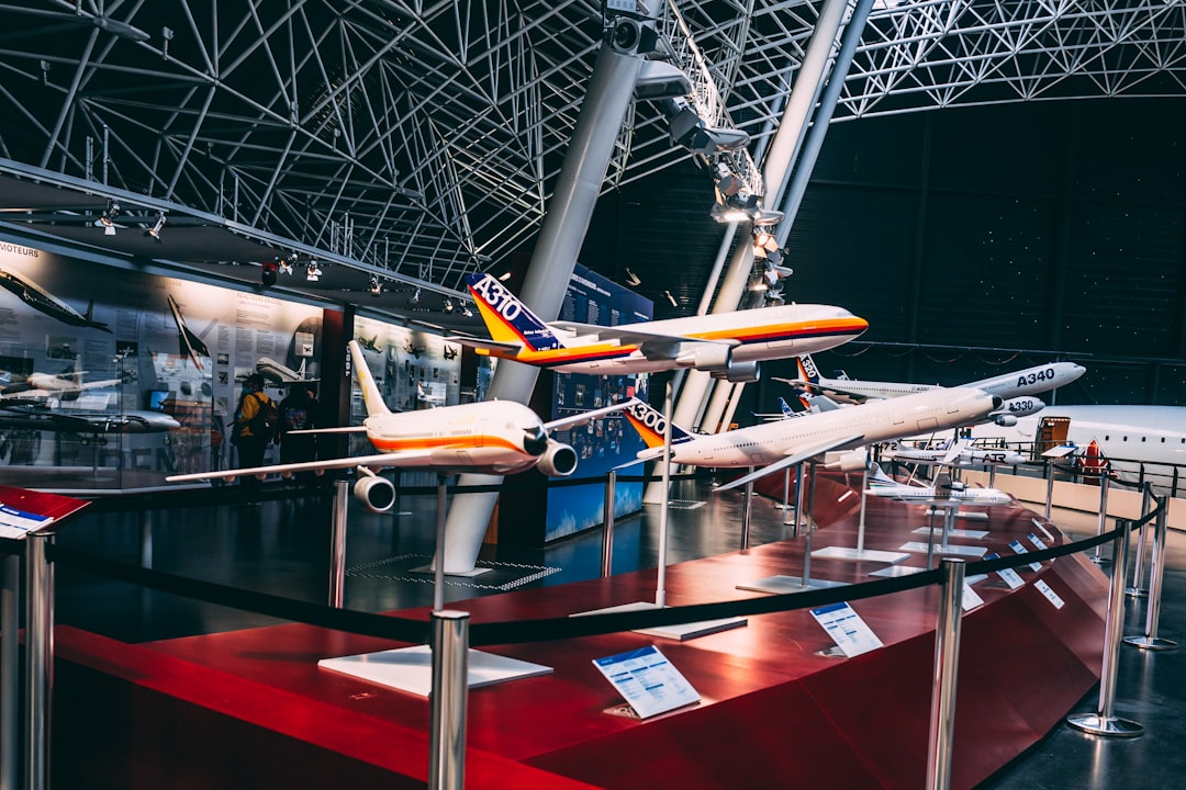 A male executive reviews aircraft models inside a Dubai Airshow exhibition hall, evaluating aerospace deals and opportunities