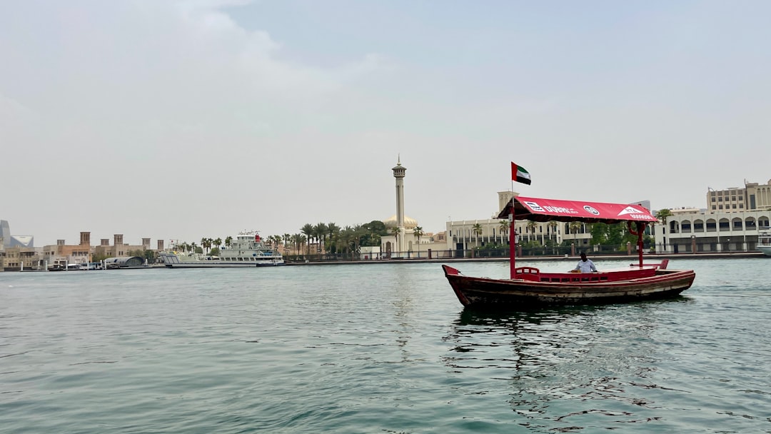 A passenger on a wooden abra crosses Dubai Creek, one of the most iconic ways to experience Arabic culture in Dubai