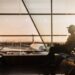 traveler-checking-phone-airport-departure-unsplash - DUBAIwebzine A traveler at Dubai International Airport checking long-haul fares on a smartphone before booking a summer flight