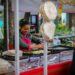 vendor-serving-shawarma-street-food-unsplash - DUBAIwebzine A vendor carefully wraps fresh shawarma at a busy street food stall in a Dubai corridor at night