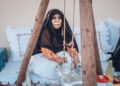 A woman enjoys a cup of gahwa in a traditional courtyard, a central ritual of Arabic culture in Dubai