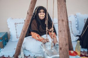 A woman enjoys a cup of gahwa in a traditional courtyard, a central ritual of Arabic culture in Dubai
