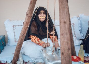 A woman enjoys a cup of gahwa in a traditional courtyard, a central ritual of Arabic culture in Dubai