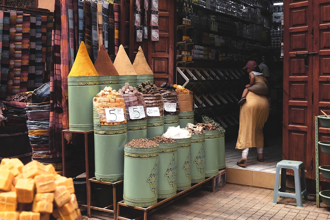 A woman purchasing loose spices package-free at a Dubai market, embracing zero waste shopping habits