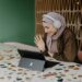 A digital nomad working at a bright coworking space in Dubai, with a laptop open and city views behind her