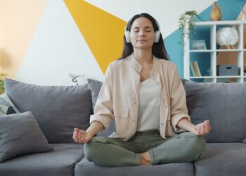 A woman practising morning meditation in her Dubai apartment, protecting her mental health during the summer.