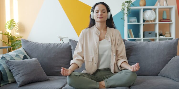 A woman practising morning meditation in her Dubai apartment, protecting her mental health during the summer.