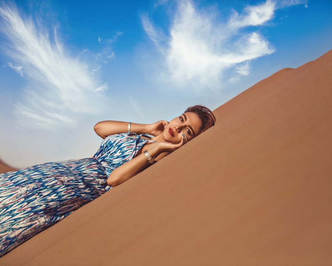 A woman with glowing skin holding a jar of organic Dubai skincare product, surrounded by warm natural tones